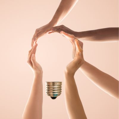 Gemeinsame Idee Hände, die zu einer Glühbirne geformt sind