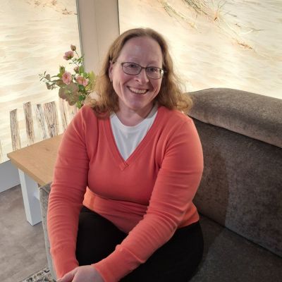 Melanie Mann und Frau meditieren stehend und schauen sich lächelnd an, halten sich an den Händen.