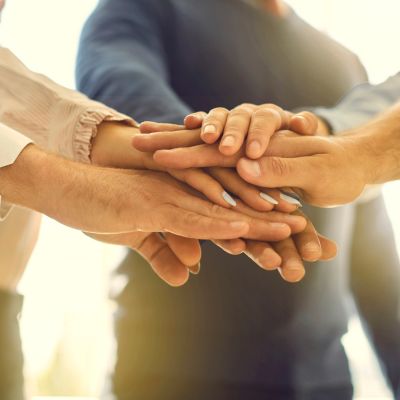 Hände in der Mitte zusammen Gruppe von Menschen, die in der Mitte ihre Hände zusammen übereinanderlegt